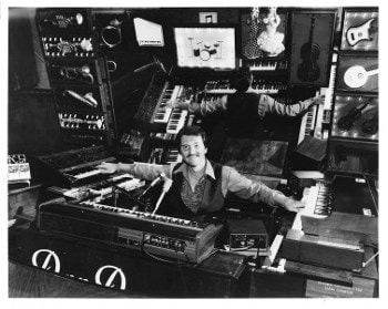 Dan Damon surrounded by his Orchestra in Keys — keyboards and lighted orchestral instruments, 1981